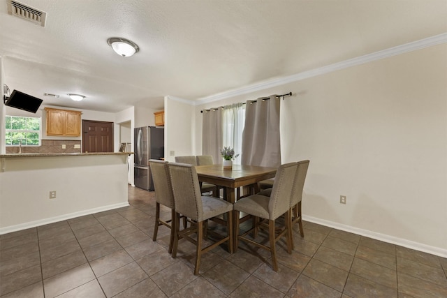 1314 Robert St, Baytown, TX 77521 - dining room with dark tile patterned flooring, ornamental molding, and baseboards