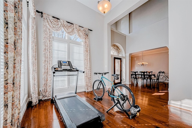 15614 Stable Brook Cir, Cypress, TX 77429 - workout area with wood-type flooring, ornate columns, a chandelier, a high ceiling, and baseboards
