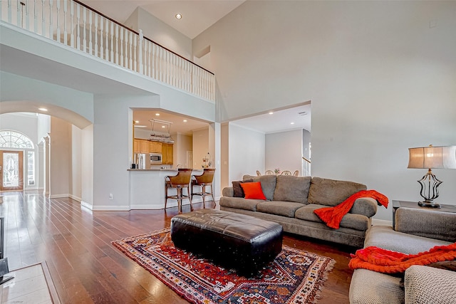 15614 Stable Brook Cir, Cypress, TX 77429 - living room with a high ceiling, arched walkways, wood-type flooring, and baseboards