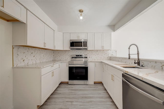 12632 Newbrook Dr, Houston, TX 77072 - kitchen featuring stainless steel appliances, light stone counters, a sink, and white cabinetry