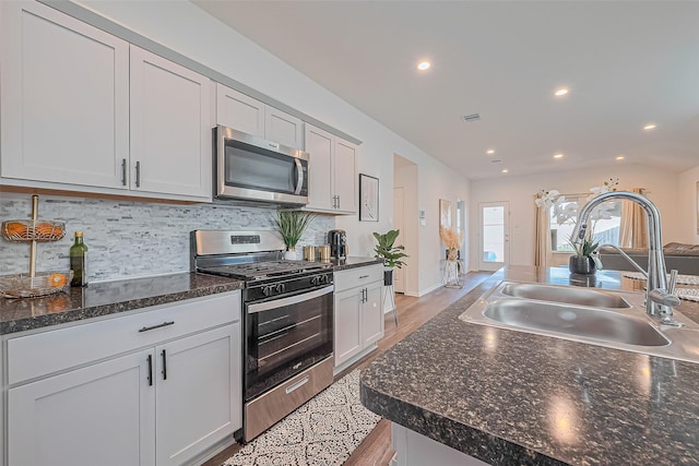 5418 Wyndham Ridge Ln, Spring, TX 77373 - kitchen featuring stainless steel appliances, a sink, dark countertops, recessed lighting, and decorative backsplash