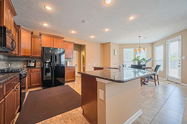 5018 Longlane Dr, Houston, TX 77084 - kitchen featuring black appliances, light tile patterned floors, brown cabinets, a sink, and decorative backsplash