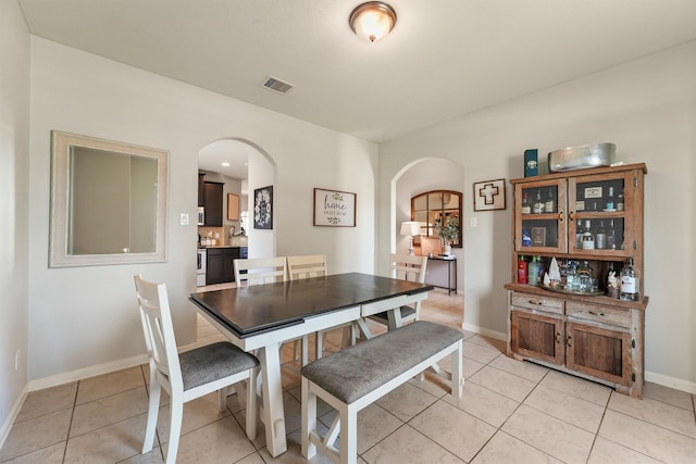 22607 August Crow Dr, Hockley, TX 77447 - dining space featuring arched walkways, light tile patterned floors, and baseboards