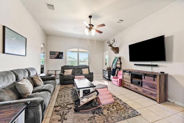 22607 August Crow Dr, Hockley, TX 77447 - living room featuring arched walkways, a ceiling fan, light tile patterned floors, and baseboards