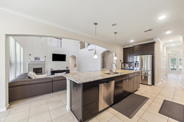 6015 Turner Shadow Ln, Sugar Land, TX 77479 - kitchen with appliances with stainless steel finishes, a sink, arched walkways, ornamental molding, and dark brown cabinets