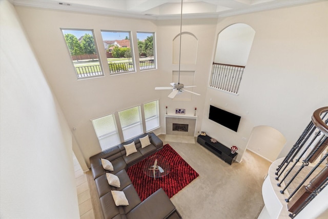 6015 Turner Shadow Ln, Sugar Land, TX 77479 - living room with a high ceiling, a fireplace, a ceiling fan, and carpet floors