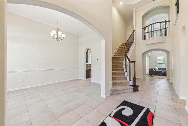 6015 Turner Shadow Ln, Sugar Land, TX 77479 - foyer with a high ceiling, a chandelier, light tile patterned flooring, baseboards, and stairway