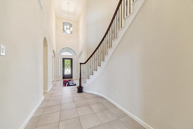 6015 Turner Shadow Ln, Sugar Land, TX 77479 - foyer featuring arched walkways, light tile patterned floors, baseboards, stairway, and a towering ceiling