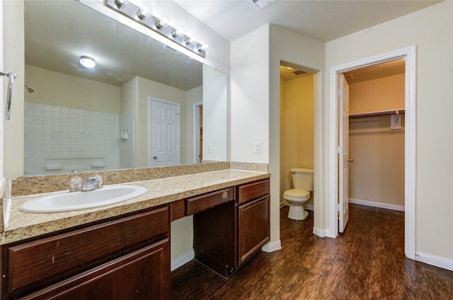 15531 Kiplands Bend Dr, Houston, TX 77014 - full bathroom featuring toilet, wood finished floors, vanity, baseboards, and a walk in closet