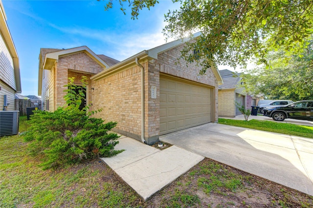 15531 Kiplands Bend Dr, Houston, TX 77014 - view of side of home featuring central air condition unit, brick siding, a garage, and driveway