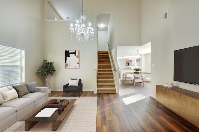 15531 Kiplands Bend Dr, Houston, TX 77014 - living room featuring a high ceiling, stairs, dark wood-style floors, a chandelier, and baseboards