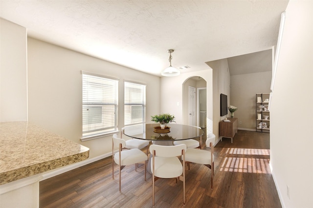 15531 Kiplands Bend Dr, Houston, TX 77014 - dining area featuring arched walkways, dark wood finished floors, and baseboards