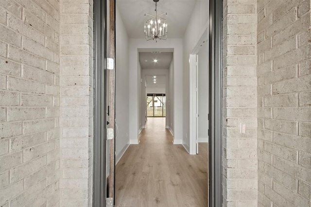 15212 Deseo Dr, Conroe, TX 77302 - hallway featuring a chandelier, light wood-style flooring, and baseboards