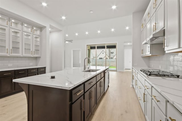 15212 Deseo Dr, Conroe, TX 77302 - kitchen featuring a sink, appliances with stainless steel finishes, under cabinet range hood, light wood-style floors, and recessed lighting