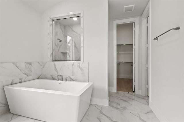 15212 Deseo Dr, Conroe, TX 77302 - bathroom with marble finish floors, a soaking tub, baseboards, a spacious closet, and a marble finish shower