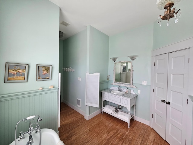 833 Kahla Dr, Crystal Beach, TX 77650 - full bathroom featuring a soaking tub, wood finished floors, vanity, and baseboards