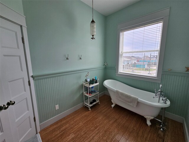 833 Kahla Dr, Crystal Beach, TX 77650 - bathroom with a wainscoted wall, wood finished floors, and a freestanding tub