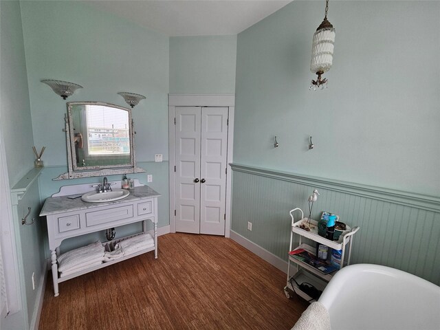 833 Kahla Dr, Crystal Beach, TX 77650 - bathroom featuring a wainscoted wall, wood finished floors, a freestanding tub, and vanity