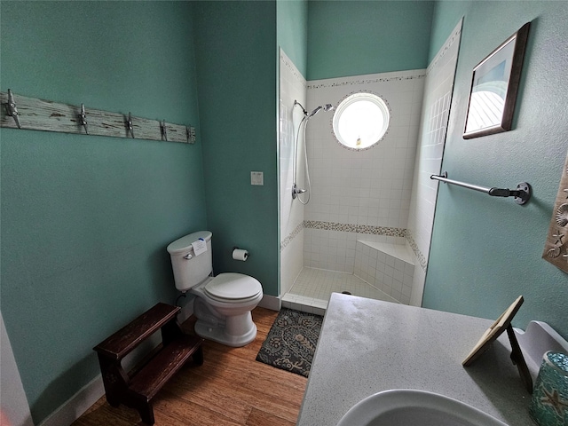 833 Kahla Dr, Crystal Beach, TX 77650 - bathroom featuring tiled shower, toilet, wood finished floors, and a sink