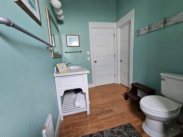 833 Kahla Dr, Crystal Beach, TX 77650 - bathroom featuring toilet, wood finished floors, baseboards, and vanity