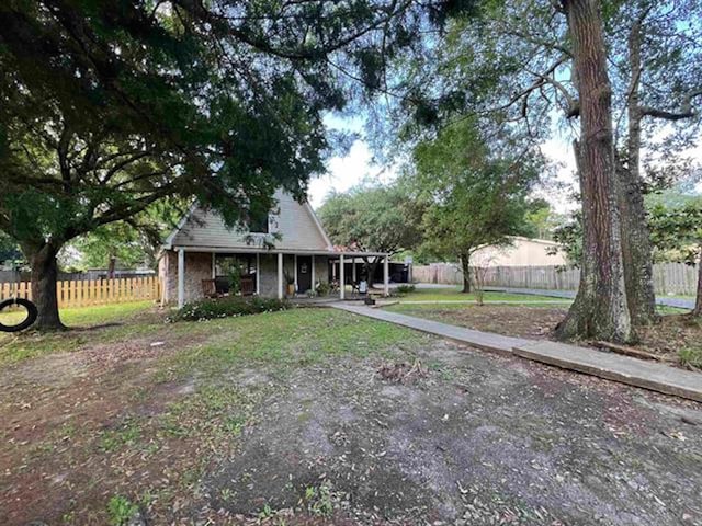 880 E Tram Rd, Vidor, TX 77662 - rear view of house with fence and a porch
