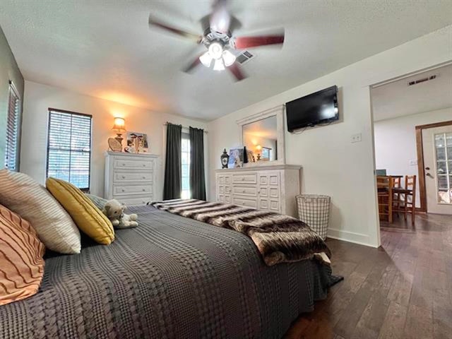 880 E Tram Rd, Vidor, TX 77662 - bedroom with dark wood-style floors, baseboards, and a ceiling fan
