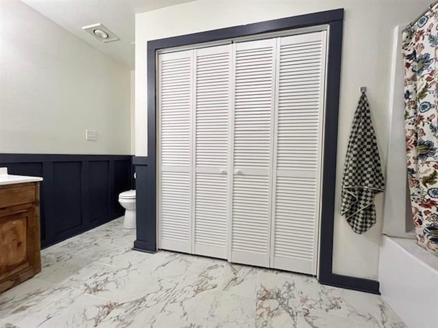 880 E Tram Rd, Vidor, TX 77662 - bathroom with marble look tile flooring, toilet, wainscoting, a closet, and vanity