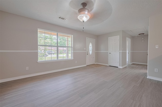 210 N Shirley Ln, Willis, TX 77378 - spare room featuring attic access, ceiling fan, light wood-style flooring, a textured ceiling, and baseboards