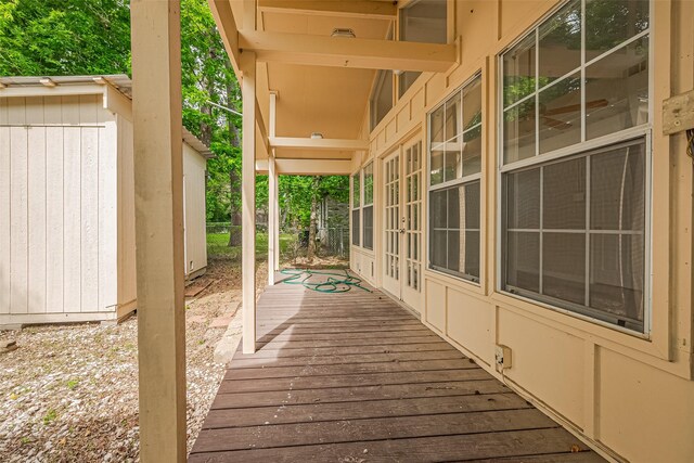 210 N Shirley Ln, Willis, TX 77378 - wooden terrace featuring french doors, a storage shed, and an outdoor structure