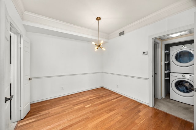 2700 Revere St Unit 138, Houston, TX 77098 - laundry area with stacked washer / dryer, crown molding, a chandelier, and light wood-style floors