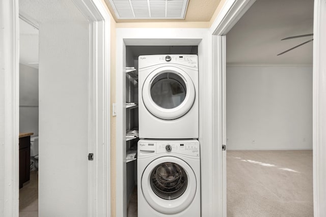 2700 Revere St Unit 138, Houston, TX 77098 - clothes washing area featuring stacked washing machine and dryer and carpet floors