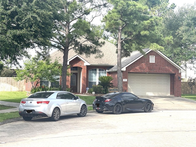 12931 Blackbrook Ln, Houston, TX 77041 - view of front facade with brick siding, driveway, fence, and an attached garage