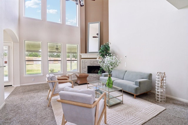 5023 Royal Arbor Ln, Houston, TX 77084 - living room featuring carpet flooring, a ceiling fan, a towering ceiling, arched walkways, and a high end fireplace