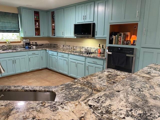 21626 Gentry Rd, Cypress, TX 77429 - kitchen with oven, stainless steel microwave, a sink, and dark stone countertops