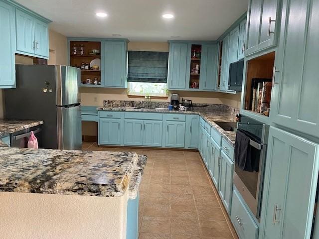 21626 Gentry Rd, Cypress, TX 77429 - kitchen with open shelves, appliances with stainless steel finishes, a sink, stone countertops, and recessed lighting