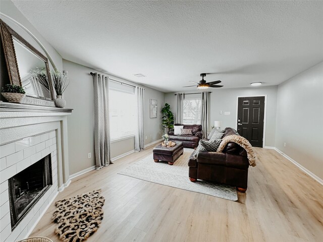 17027 Sperry Landing Dr, Houston, TX 77095 - living area featuring light wood-style floors, a fireplace, baseboards, and a textured ceiling