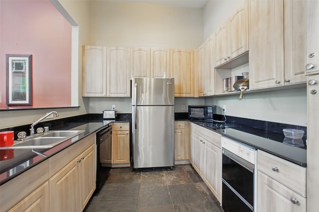 1330 Old Spanish Trl Unit 7207, Houston, TX 77054 - kitchen with black appliances, a sink, light brown cabinetry, dark countertops, and dark stone finish floors