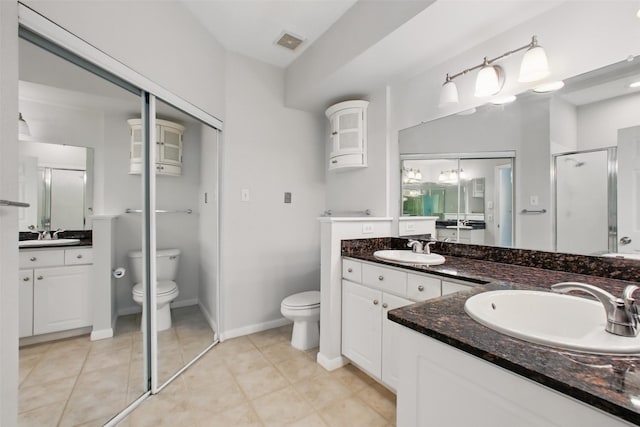 1330 Old Spanish Trl Unit 7207, Houston, TX 77054 - bathroom with toilet, a shower stall, two vanities, baseboards, and tile patterned flooring