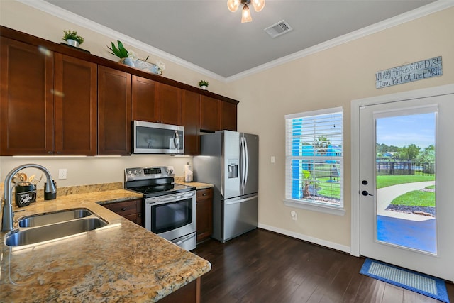 607 29th St, Dickinson, TX 77539 - kitchen featuring stainless steel appliances, a sink, crown molding, light stone countertops, and dark wood-type flooring