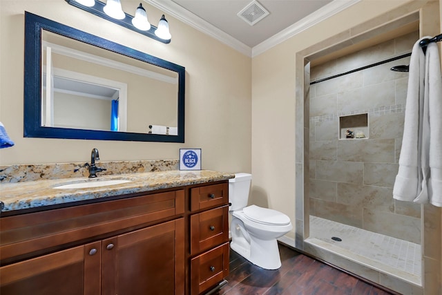 607 29th St, Dickinson, TX 77539 - full bathroom featuring wood finished floors, vanity, toilet, crown molding, and a tile shower
