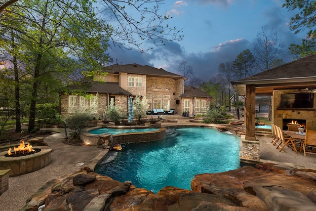 27433 S Lazy Meadow Way, Spring, TX 77386 - view of pool featuring an outdoor fire pit, a patio, a pool with connected hot tub, and an outdoor stone fireplace