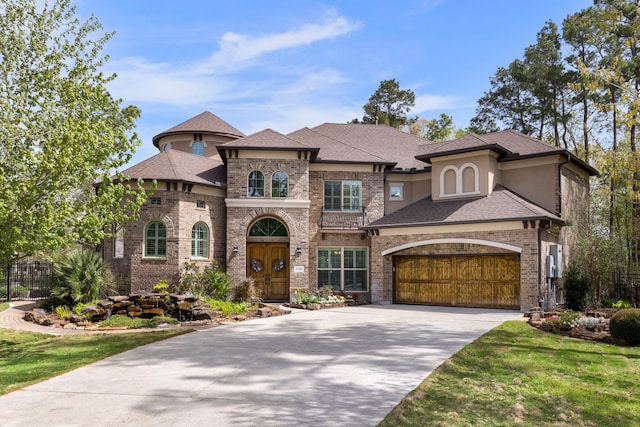 27433 S Lazy Meadow Way, Spring, TX 77386 - french country style house with concrete driveway, brick siding, an attached garage, stucco siding, and a shingled roof