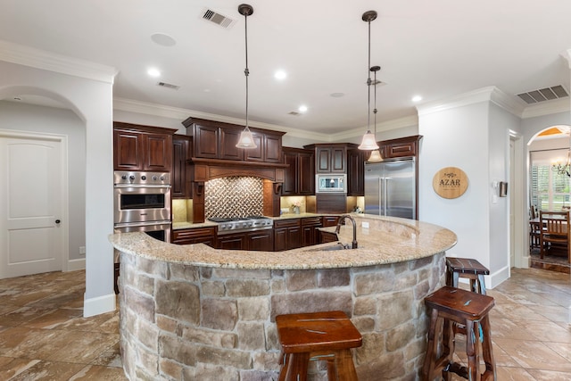 27433 S Lazy Meadow Way, Spring, TX 77386 - kitchen with built in appliances, arched walkways, a sink, stone tile floors, and baseboards