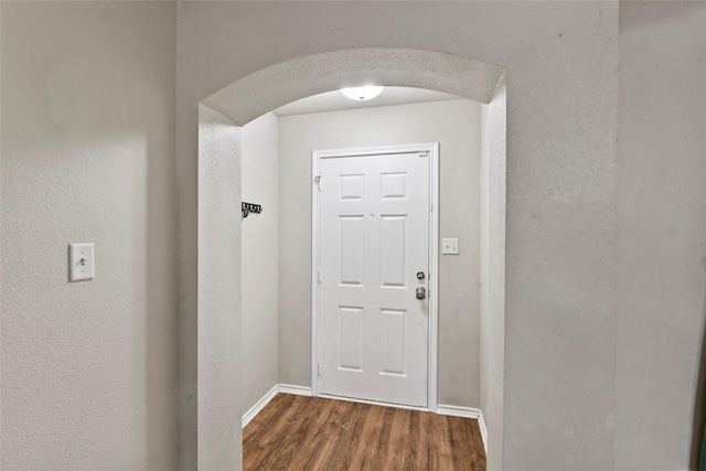1160 Cottage Grove Cir, Bryan, TX 77801 - doorway with arched walkways, dark wood-type flooring, and baseboards