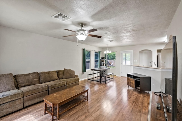 1160 Cottage Grove Cir, Bryan, TX 77801 - living area featuring a ceiling fan, a textured ceiling, wood finished floors, and a chandelier