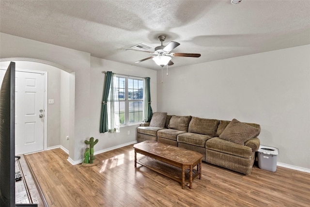 1160 Cottage Grove Cir, Bryan, TX 77801 - living area featuring arched walkways, wood finished floors, baseboards, a ceiling fan, and a textured ceiling
