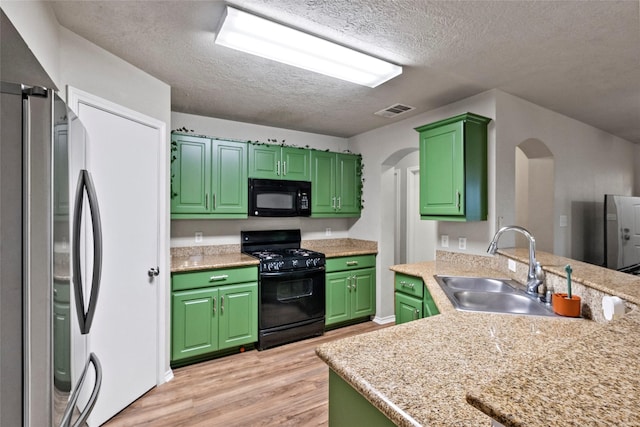 1160 Cottage Grove Cir, Bryan, TX 77801 - kitchen with black appliances, green cabinets, a sink, and a textured ceiling