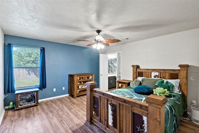 1160 Cottage Grove Cir, Bryan, TX 77801 - bedroom with a textured ceiling, wood finished floors, baseboards, and a ceiling fan