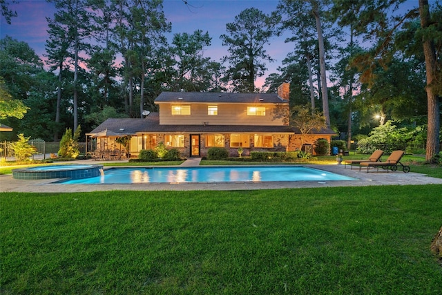 1710 Magnolia Ln, Kingwood, TX 77339 - pool at dusk featuring a patio and a pool with connected hot tub