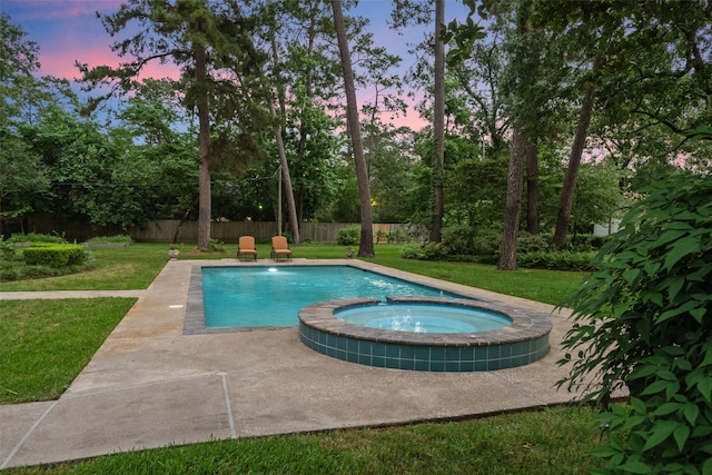 1710 Magnolia Ln, Kingwood, TX 77339 - pool at dusk featuring a pool with connected hot tub and a patio